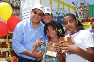 1.- John Sachtouras entrega a dos niños productos.