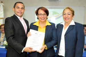 Rafael Ovalles y Luisa Fernández entregan certificado a egresada