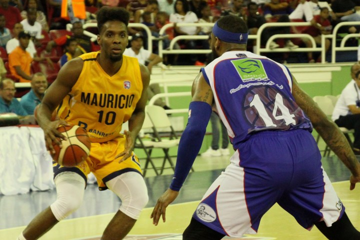 Gerardo Suero, del club Mauricio Báez, defendido por Jonathan Moore, de San Lázaro